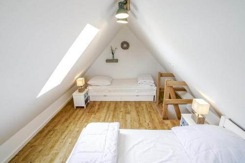 TossenserdeichにあるFerienhaus 16 "Gut Tossens"の屋根裏のベッドルーム(ベッド1台、はしご付)