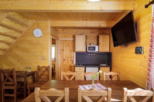 una habitación con mesa y TV en una cabaña en Lopušná dolina Resort, en Vysoké Tatry