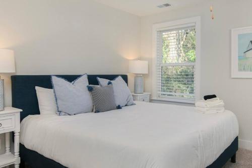 ein Schlafzimmer mit einem großen Bett mit blauen und weißen Kissen in der Unterkunft Spacious Charleston - 6 mins to beach & Downtown in Charleston
