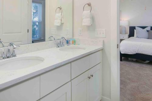 ein weißes Badezimmer mit zwei Waschbecken und einem Bett in der Unterkunft Spacious Charleston - 6 mins to beach & Downtown in Charleston