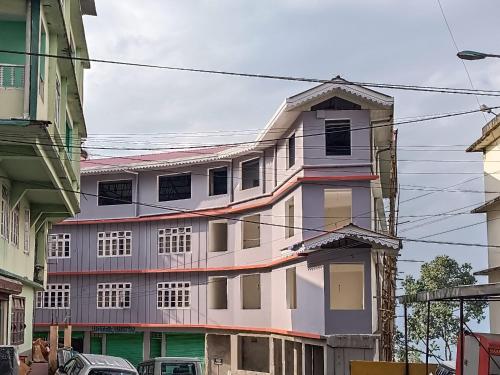 a white building with many windows on a street at HOTEL SILVER in Pakyong