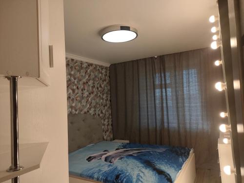 1 dormitorio con cama y ventana en Двухкомнатная квартира в самом центре Актобе, en Aktobe