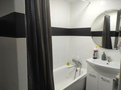 a bathroom with a tub and a sink and a mirror at Двухкомнатная квартира в самом центре Актобе in Aktobe