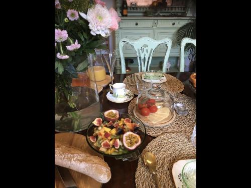 a table topped with plates of food and flowers at Champagne House - Elegance, Luxury and Charm in Condom