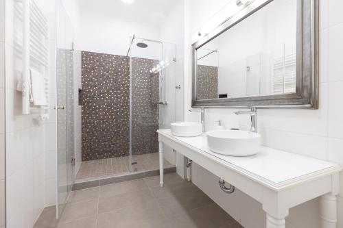 a white bathroom with two sinks and a shower at Degenfeld Kastély Tóparti Vendégház in Téglás