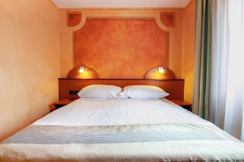 a bedroom with a large bed with two pillows at Al Giardinetto in Biasca