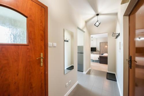 a hallway with a wooden door and a bedroom at Ursus Pleasant Apartment in Warsaw
