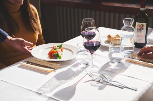 a table with a plate of food and wine glasses at Hotel Mondolé - Azzurro Club in Prato Nevoso