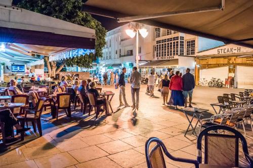 eine Gruppe von Personen, die in einem Restaurant im Freien an Tischen sitzen in der Unterkunft Dimore Italiane - Boutique Apartments in Corralejo