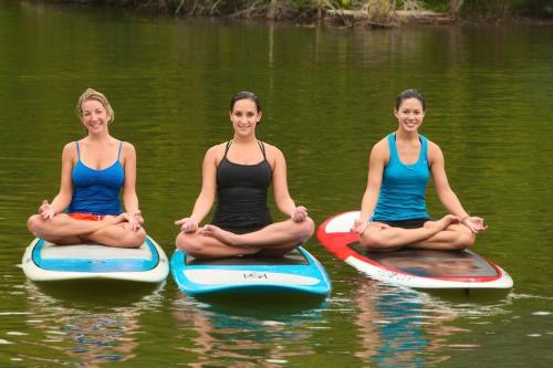three women sitting on surfboards in the water at Turnberry accommodation in Turnberry