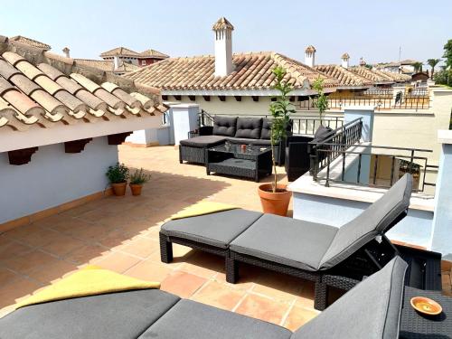 a patio with a couch and chairs on a roof at Casa Benks - Mar Menor Golf in Torre-Pacheco