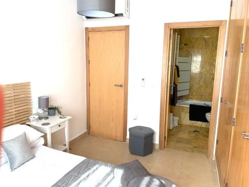 a bedroom with a bed and a bathroom with a tub at Casa Benks - Mar Menor Golf in Torre-Pacheco