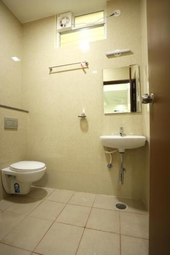 a bathroom with a toilet and a sink at Hotel Sigma Suites in Bengaluru
