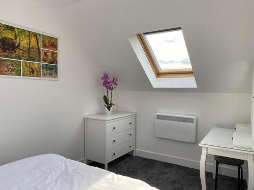 a bedroom with a bed and a desk and a window at Fig Cottage Holiday Home in Whitecroft