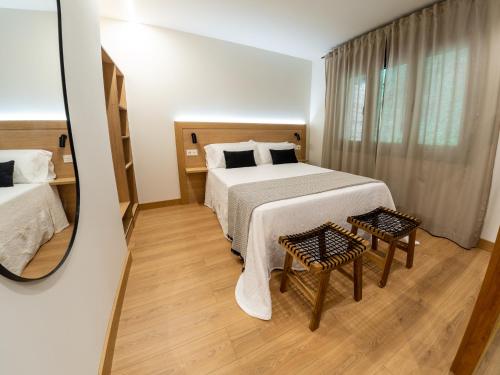 una camera d'albergo con letto e specchio di Apartamentos Vior y Valdés a Cudillero