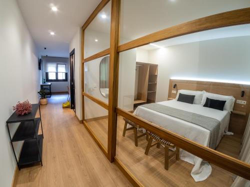 una camera con un letto e un grande specchio di Apartamentos Vior y Valdés a Cudillero