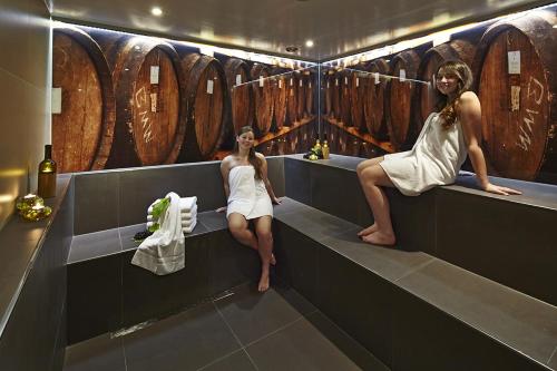 two women sitting on a bench in a wine cellar at WeinBergHotel Nalbach in Reil