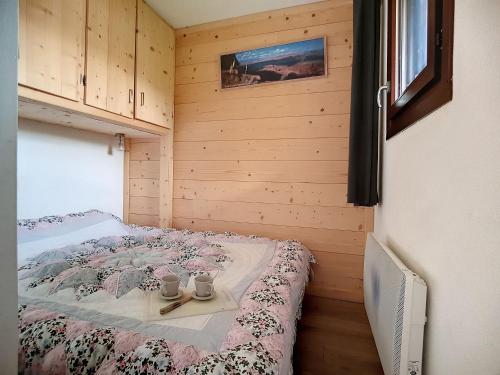 ein Schlafzimmer mit einem Bett mit zwei Tassen drauf in der Unterkunft Appartement Les Menuires, 3 pièces, 6 personnes - FR-1-344-767 in Les Menuires