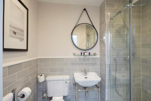 a bathroom with a toilet and a sink and a mirror at Sentry Mead Hotel in Totland