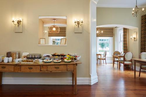 a kitchen and dining room with a table with food on it at Sentry Mead Hotel in Totland
