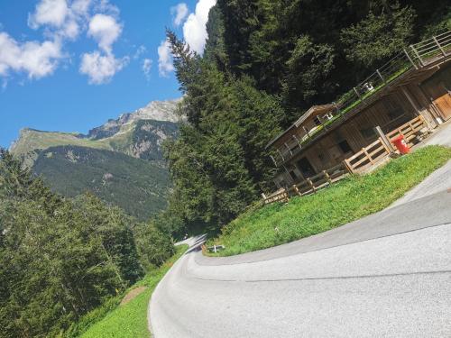 a winding road in the mountains with a house at Ferienhaus Gaishütte in Ginzling
