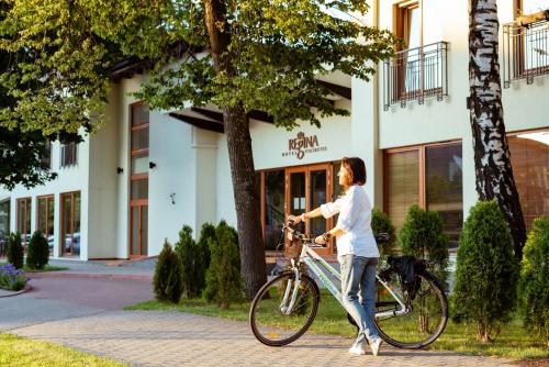 una mujer está montando una bicicleta en una acera en Regina, en Druskininkai