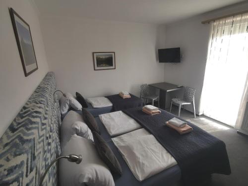 a bedroom with two beds and a table and a television at Pension Kiwi in Mikulov