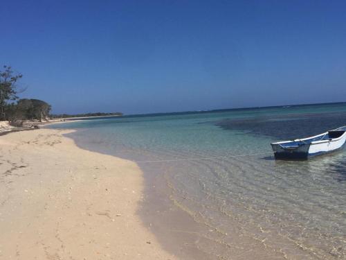 a boat sitting on the shore of a beach at Punta Rucia Cristal Beach in Punta Rucia