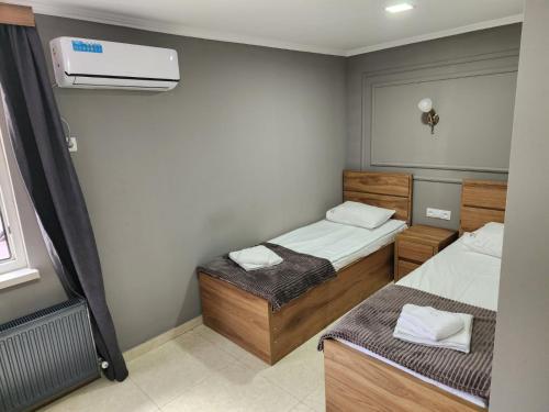 a small room with two beds and a air conditioner at Hotel Rose in Tbilisi City