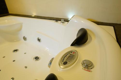 a white bath tub with a remote control in it at Depar de lujo duplex familiar con Jaccuzi in Cuenca