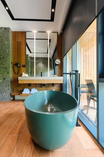 a large blue tub in the middle of a bathroom at Hotel Uji Ftohte Tepelene in Tepelenë