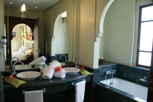 a bathroom with two sinks and a large mirror at La Kasbah Aalma D'or in Najem