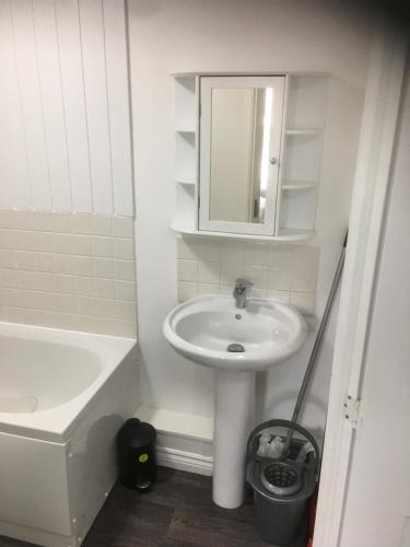 Baño blanco con lavabo y espejo en Beautiful 2 bed apartment with Parking and Wifi and 3 Smart TV's en Great Oakley