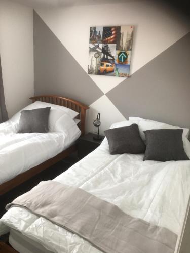 a bedroom with two beds and a painting on the wall at Beautiful 2 bed apartment with Parking and Wifi and 3 Smart TV's in Great Oakley