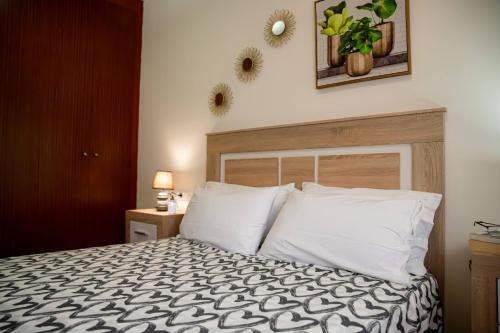 1 dormitorio con 1 cama con almohadas blancas en Apartamento Poleo en Icod de los Vinos