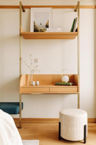 a bedroom with a wooden shelf and a ottoman at Aethos Ericeira in Ericeira