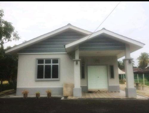 a small white house with at Nor Su Homestay in Kampong Alor Gajah