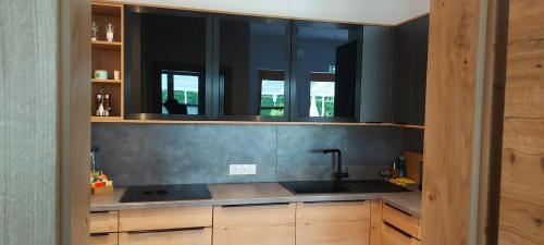 a kitchen with a sink and two mirrors above it at Apartment Tamara's in Heiligen Gestade