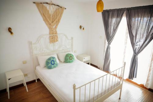 a bedroom with a white bed with blue pillows at Parva Port in Alacati