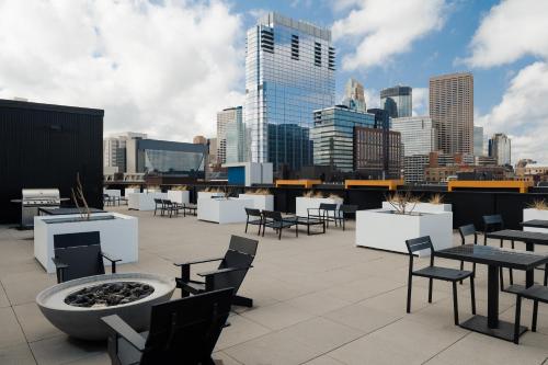 a rooftop with tables and chairs and a city skyline at Sonder at SECOND & SECOND in Minneapolis