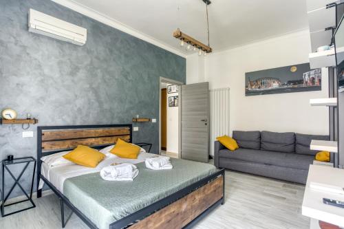 ローマにあるSAPIENZA Grand Apartmentのベッドルーム1室(黄色い枕とソファ付きのベッド1台付)