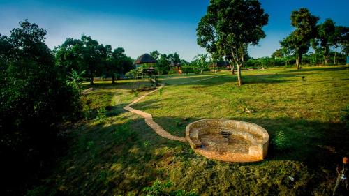 a stone bowl in a field with a path at Buyala Bliss on the Nile in Jinja