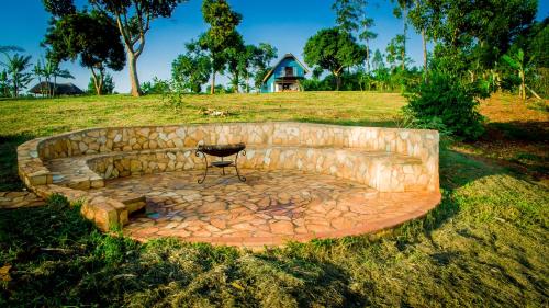 a stone bench in a field with a table on it at Buyala Bliss on the Nile in Jinja