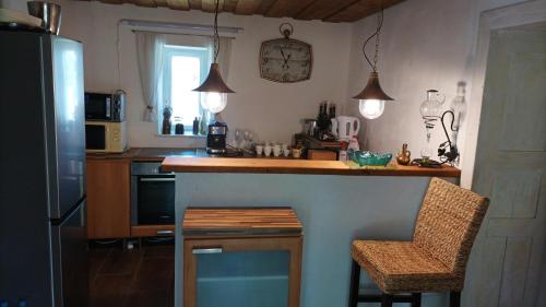cocina con encimera, mesa y sillas en Guesthouse Tulipán Vendégház, 