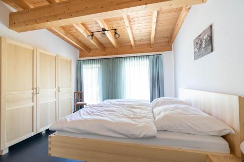 una camera da letto con un letto con lenzuola bianche e una finestra di Fewo am Aubach-Josefine a Blaichach