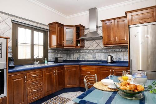 a kitchen with wooden cabinets and a bowl of food on a table at Casa Jolatero Ventana al Charco in Arrecife