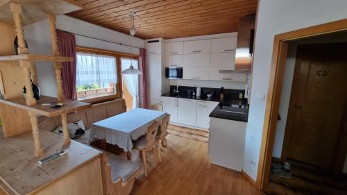a kitchen with white cabinets and a table in a room at Schlernwohnung in Seis am Schlern in Siusi
