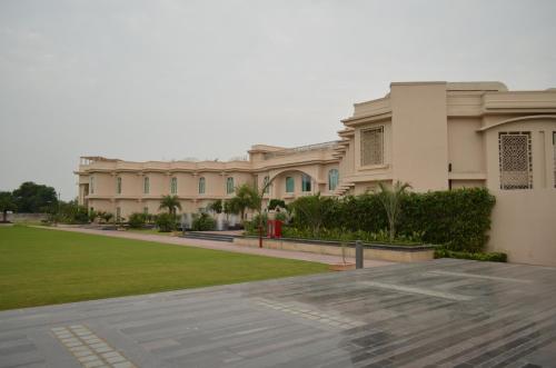 a large building with a lawn in front of it at The Umrao in New Delhi