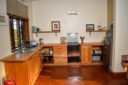 a kitchen with wooden cabinets and a refrigerator at Buyala Bliss on the Nile in Jinja