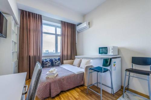 a small room with a small table and a kitchen at Smart House 11 in Kyiv